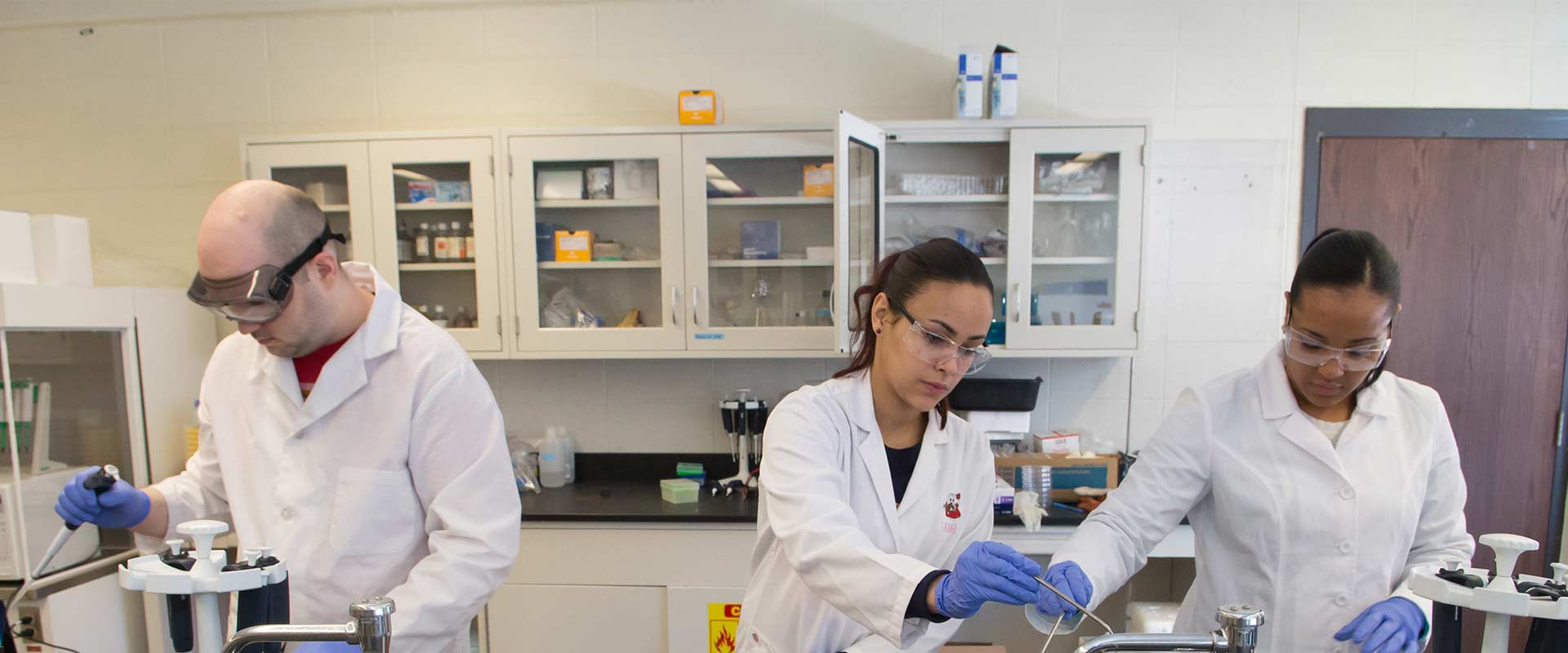 Three students working in a science lab