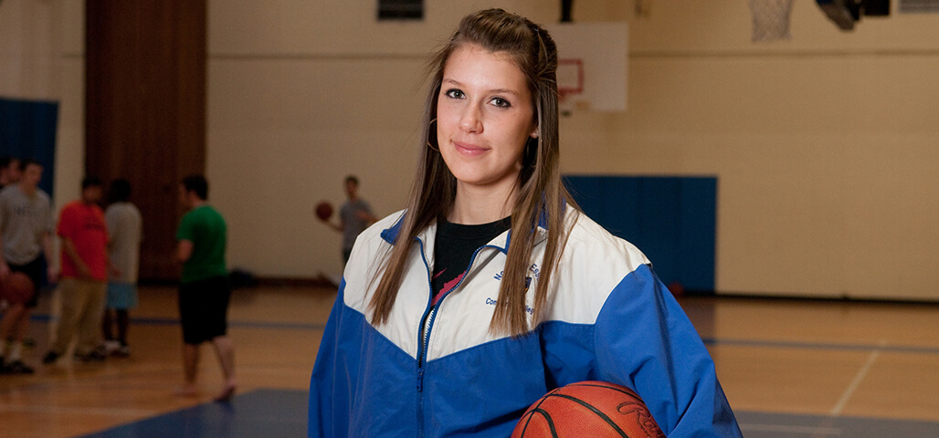 A female Exercise Science student on the basketball court.
